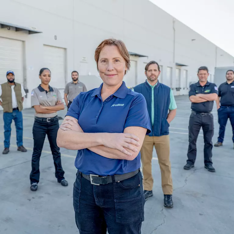 Group of male and female ArcBest drivers standing outside a service center.